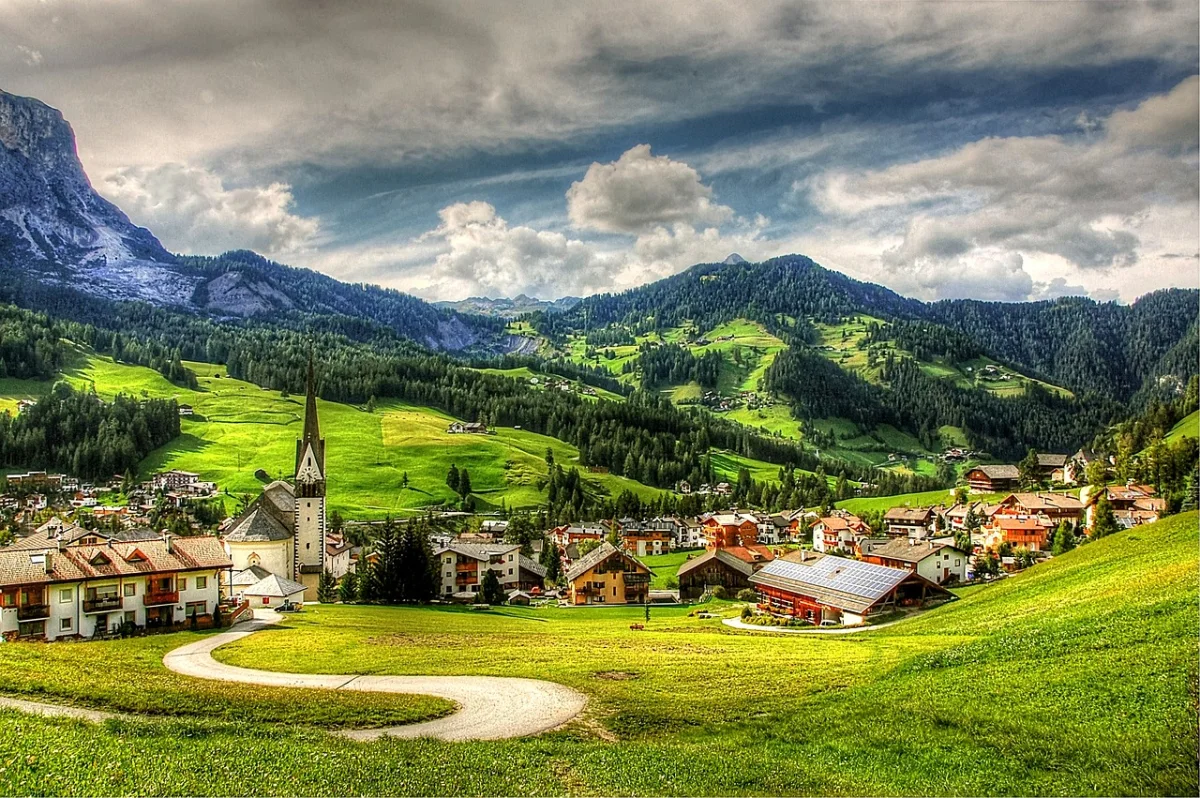A green Alta Badia village beneath the Dolomites