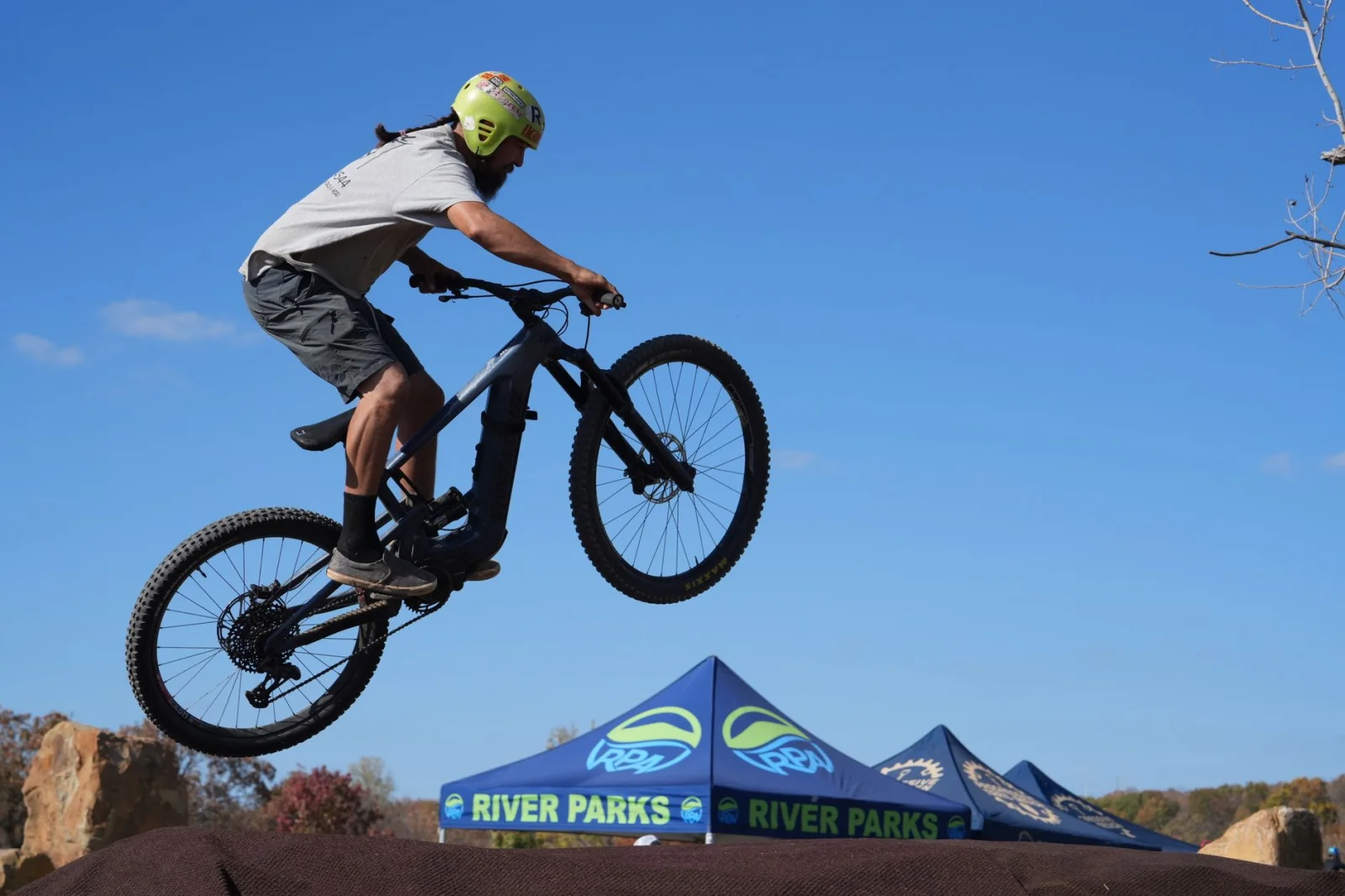 Mountain biker performing a jump during a sunny day event