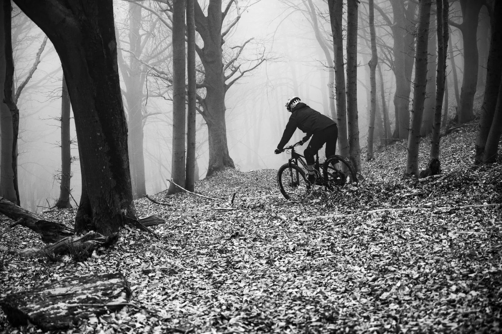 Mountain biker riding through a foggy forest in Finale Ligure, Italy