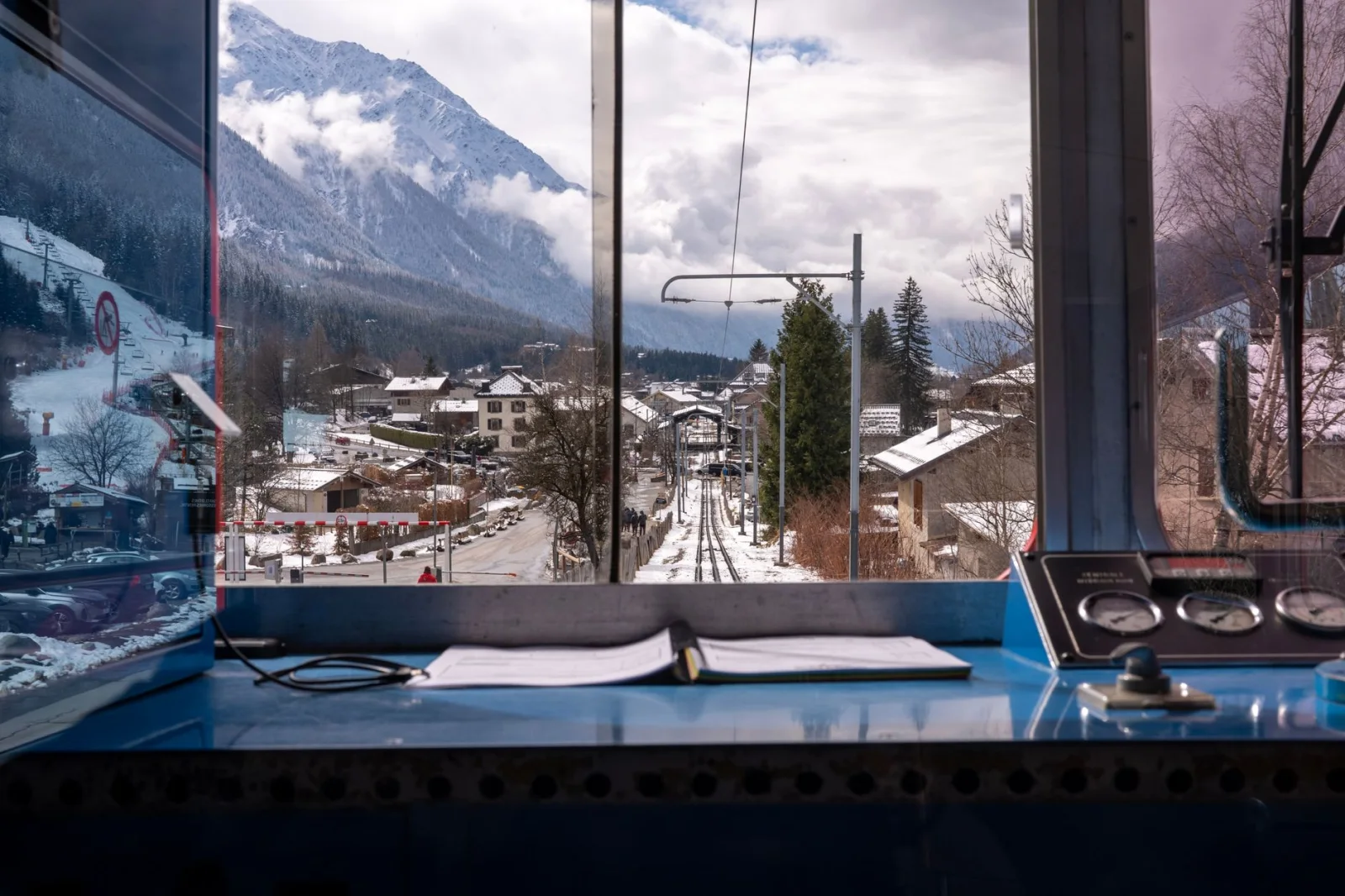 View from inside a train cabin over snowy Chamonix-Mont-Blanc village and mountains