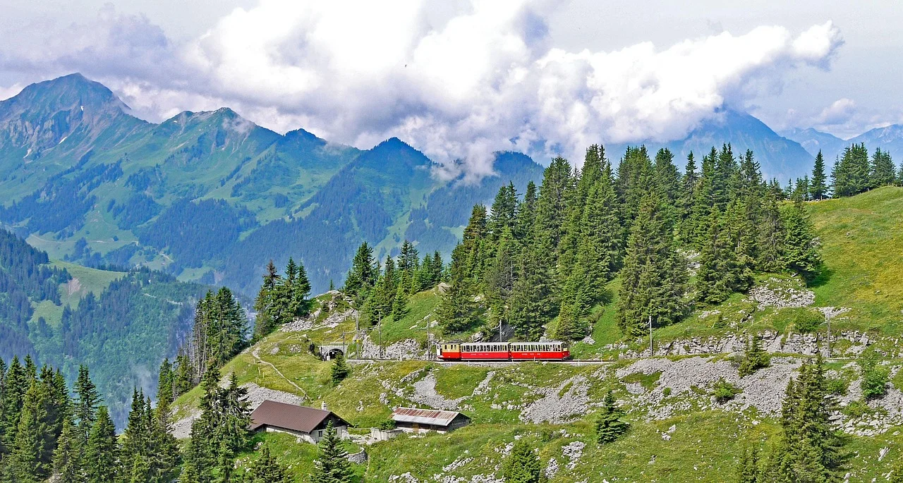 Mountain railway winding through green Alpine hillside near the Jungfrau region above Interlaken