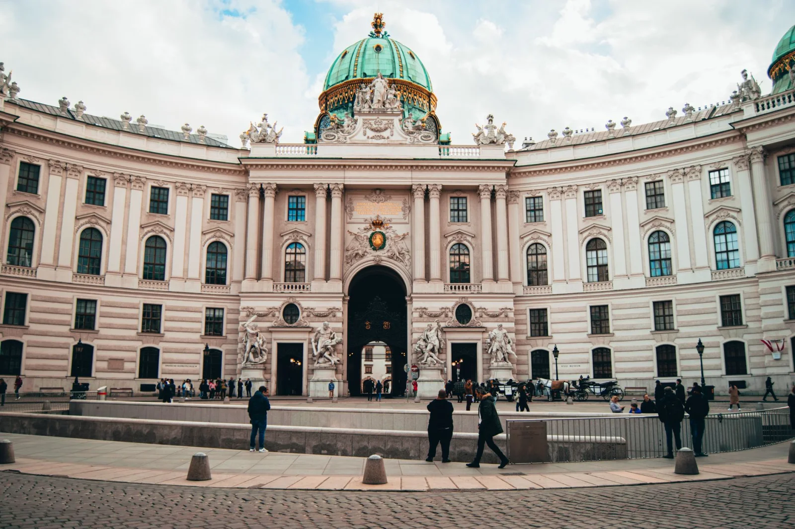 Hofburg Palace facade in Vienna with visitors in the courtyard