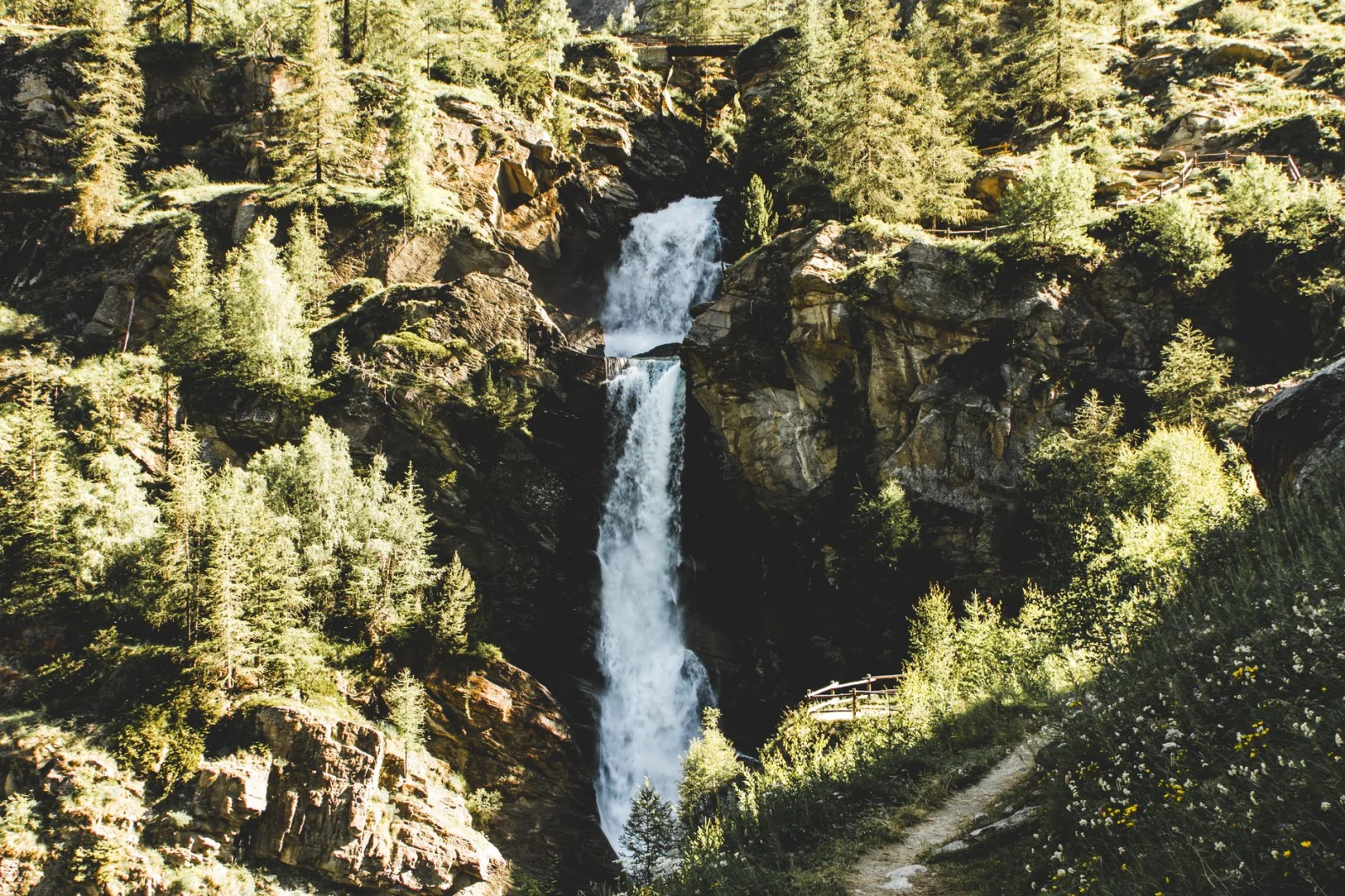 Gorgeous long exposure of Lillaz Waterfalls surrounded by lush forest in summer.